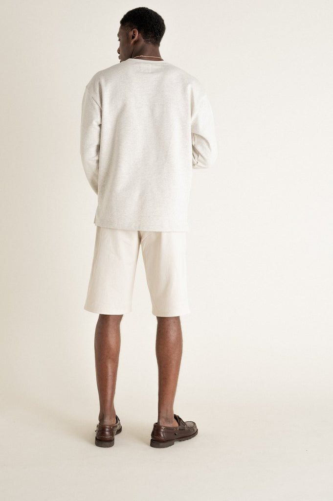 Un homme de dos porte un sweat gris en coton biologique de la marque Noyoco.