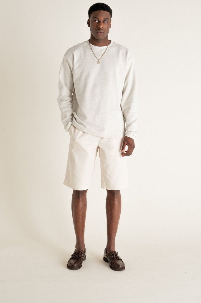 Un homme de face porte un sweat gris en coton biologique de la marque Noyoco.