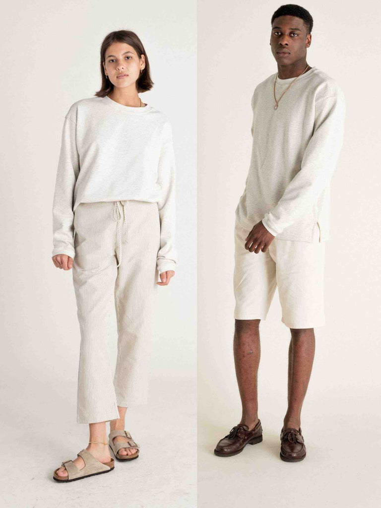 Un homme et une femme portent le même sweat gris en coton biologique de la marque Noyoco.