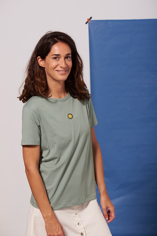 Photo d'un mannequin portant un t shirt brodé manches courtes bleu avec un patch soleil en coton bio et fabriqué au Portugal.