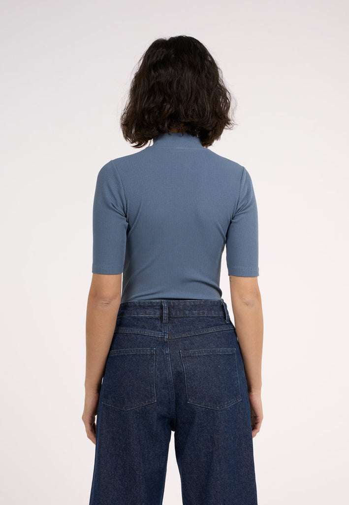 Photo d'un mannequin de dos portant un t-shirt col cheminée bleu en coton bio et fabriqué en Turquie.