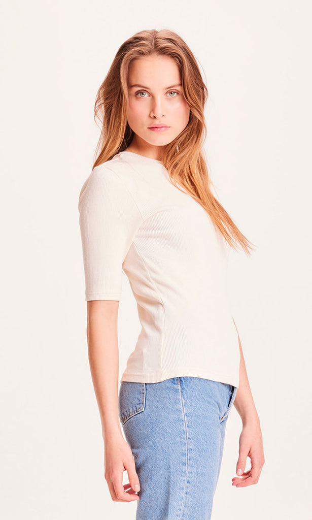 Photo d'une femme de profil portant un t shirt cotele pour femme ecru en coton bio de la marque knowledge cotton apparel.