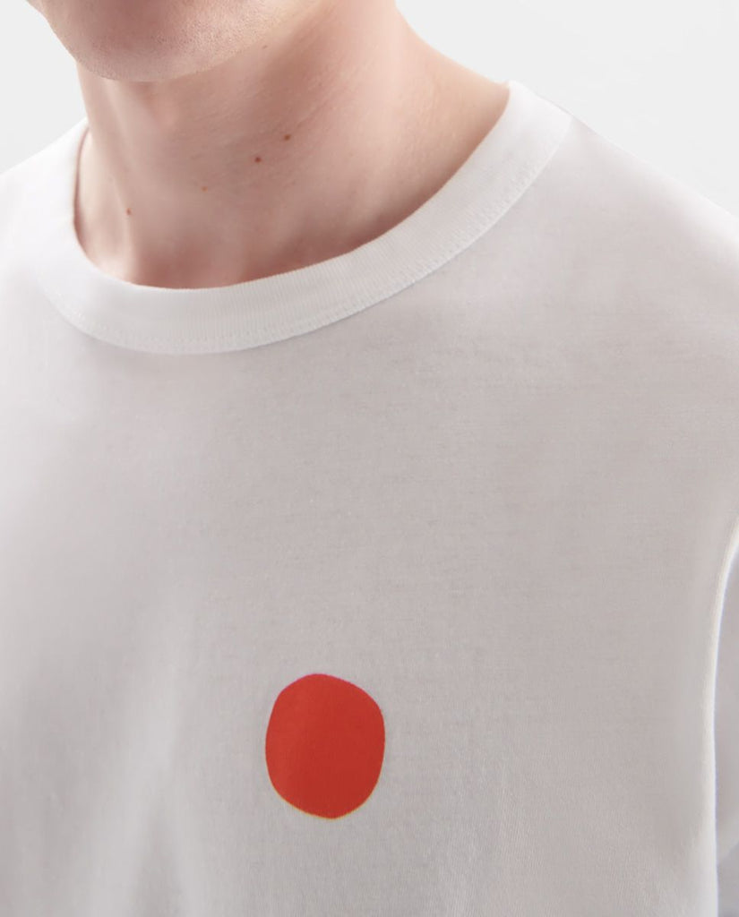 Photo zoomée d'un mannequin portant un t shirt en coton bio blanc avec rond rouge sur la poitrine et fabriqué au Portugal.