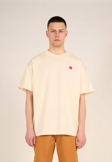 Photo d'un mannequin portant un t-shirt loose crème et fabriqué en Europe.