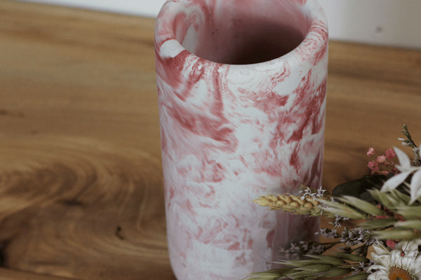 Photo d'un vase effet marbré en béton rose avec des fleurs séchées réalisé à la main par la Fabrik en France. 