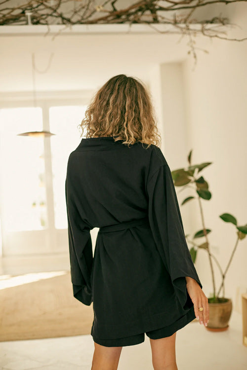 Photo d'un mannequin de dos portant une veste kimono pour femme noire en lyocell et fabriqué au Portugal.