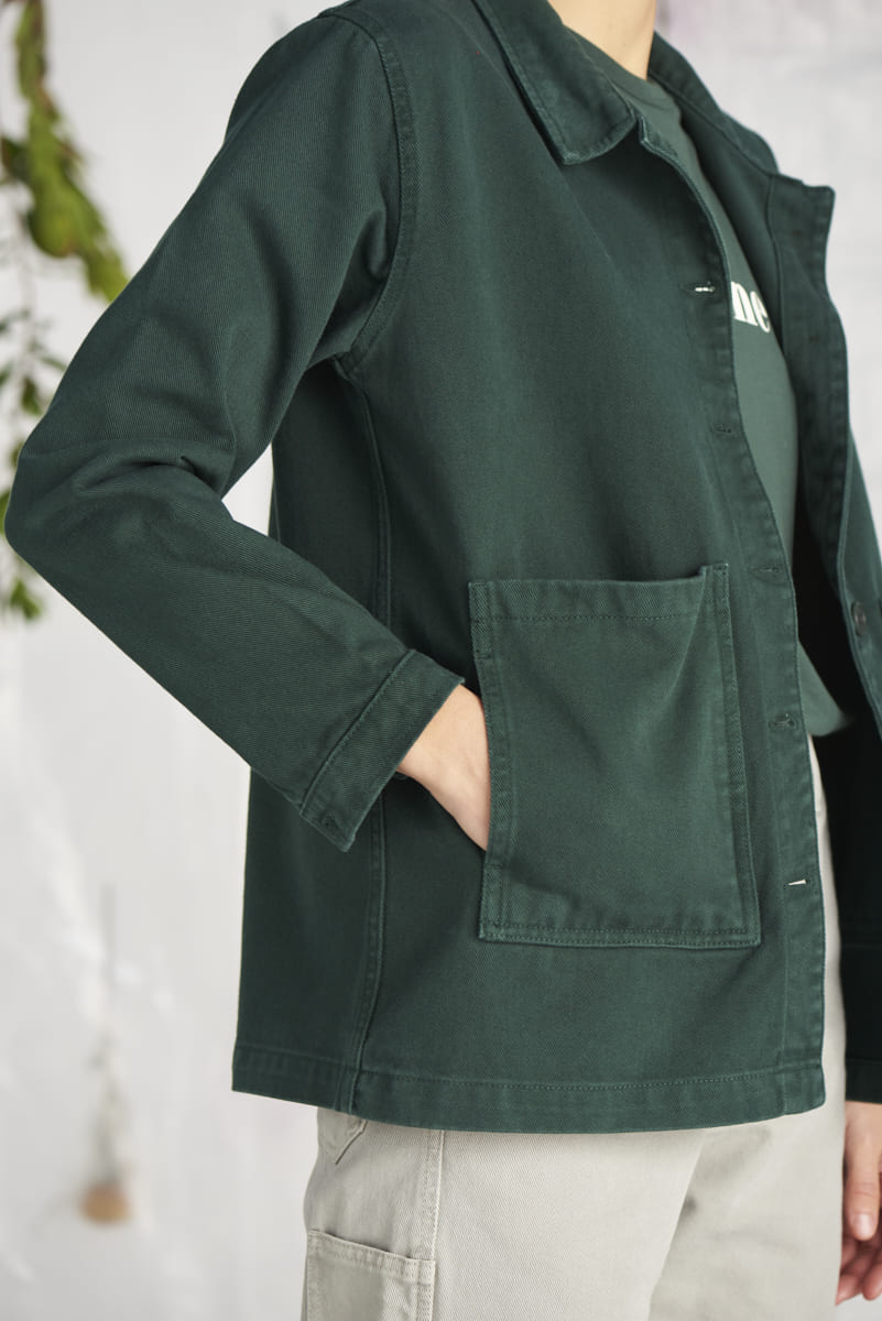 Une femme sur le côté porte une veste Graine verte en coton biolgique.